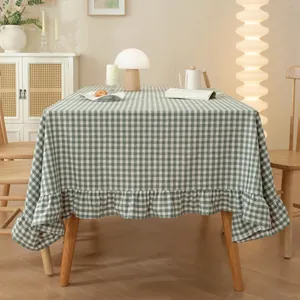 Close-up of green and beige checkered tablecloth featuring elegant ruffled lace edges