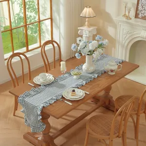 Franse vintage blauw geruite katoenen tafelloper met elegante ruches op een houten tafel