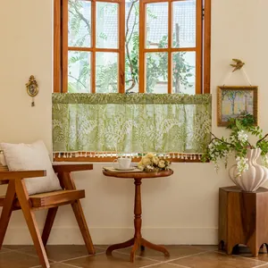 Detail of green kitchen curtain with white leaf pattern and elegant tassel trim