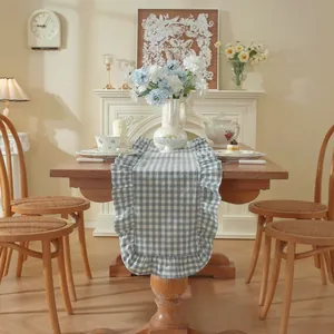 Franse vintage tafelrunner blauw wit geblokt met ruches op een houten eettafel