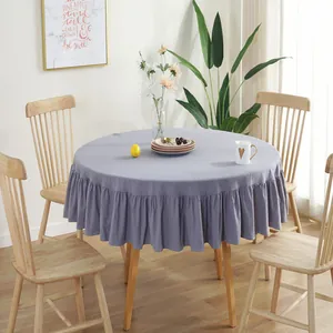 Detail of lavender round tablecloth with elegant ruffled edge on a wooden table