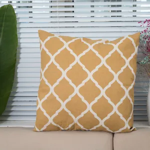 Detail of square ginger linen pillow cover with white Moroccan clover pattern on a sofa
