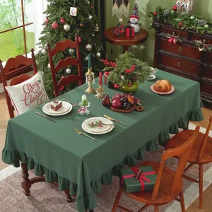 Detail van donkergroen katoenen tafelkleed met ruches voor kersttafel decoratie