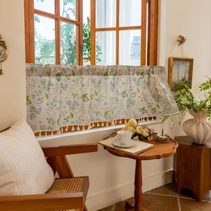 Detail of floral linen cafe curtain with decorative fringe trim in French country style