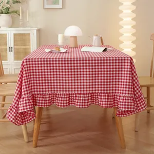 Detailed view of red gingham checkered tablecloth with elegant ruffled edge and soft fabric
