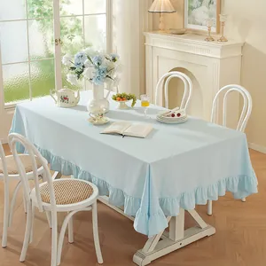 Vue détaillée d'une nappe bleu clair à volants avec un beau drapé sur une table rectangulaire
