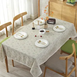 Blumige Tischdecke aus Baumwollleinen mit weißer Spitze auf einem Holztisch