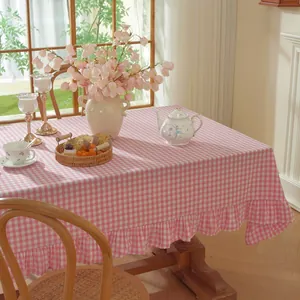 Pink and white checkered tablecloth featuring elegant ruffled edges on a wooden table