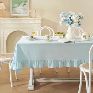 Détail d'une nappe en coton bleu clair avec bordure à volants au style pastoral français