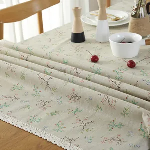 Blumige Baumwoll-Leinen-Tischdecke mit weißer Spitze auf einem Holztisch