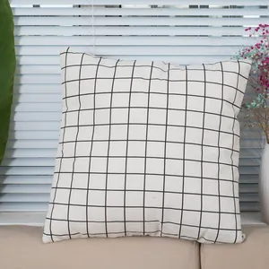 Minimalist square linen throw pillow cover with black grid pattern on a beige sofa