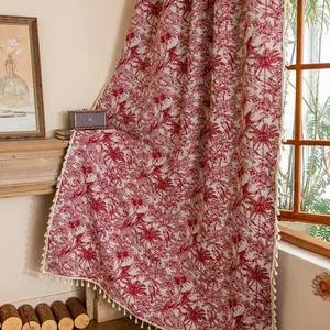Detail van bohemien rode gordijnen met palmpatronen en beige franje met kwastjes