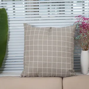 Detail of gray checkered linen pillow cover texture on a soft beige home sofa