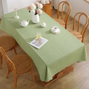 Macro detail of green and white gingham tablecloth on a wooden table with ceramic tea set
