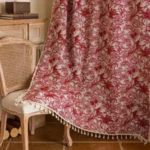 Detail van vintage gordijn met rode bloemmotieven en beige franjes voor de kamer