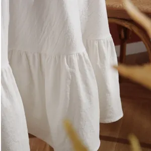 Minimalist white cotton tablecloth with ruffled edges and natural pleated texture