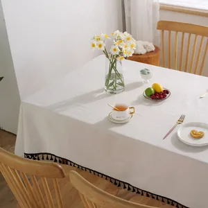 Detailaufnahme der weißen Baumwoll-Leinen Tischdecke mit eleganten schwarzen Fransen