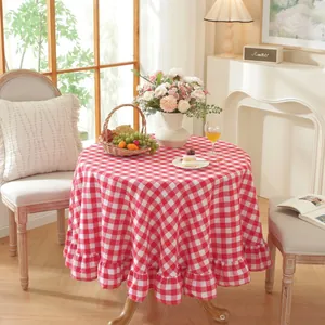 Detail of red and white checkered round tablecloth with elegant ruffled edge draping