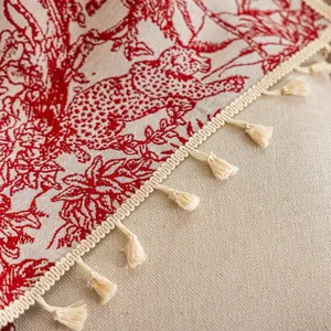 Detail van vintage Toile de Jouy-stof met rode bloemenpatronen en beige franjes