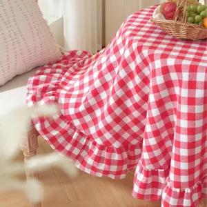 Detailed view of red and white gingham tablecloth with decorative ruffled edge design