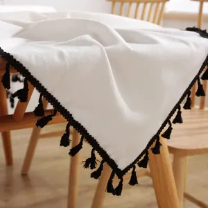 Detailaufnahme der Tischdecke aus Leinen mit strukturierter Optik und schwarzen Quasten