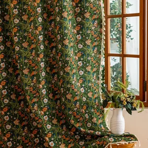 Detail van vintage bloemengordijn met groene damastpatronen en witte franje aan de rand