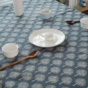 Vue détaillée de la nappe en coton et lin bleu foncé avec motifs d'arbres de forêt blancs