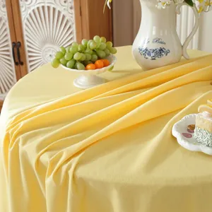 Detail of premium mustard yellow washed cotton tablecloth with elegant micro-pleat texture