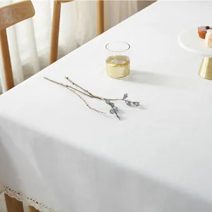 Nahaufnahme der weißen Baumwoll-Leinen-Tischdecke mit eleganter Spitzenkante auf Holztisch