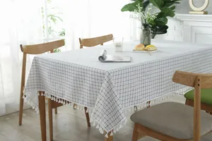 Detailed view of the blue and white checkered tablecloth with decorative fringe borders
