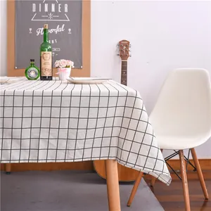 Detail of modern black and white plaid tablecloth showing fabric drape on wooden table