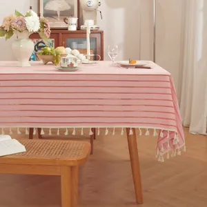 Detail van roze gestreept tafelkleed met elegante witte kwastjes en linnen textuur