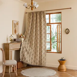 Detail van rood jacquard gordijn met vintage bloemmotieven en witte franjes aan de rand