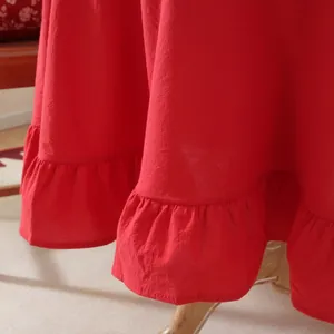 Detail of red textured cotton fabric showing the ruffle hem and soft drapery