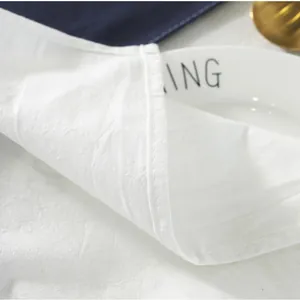 Detail of white cotton linen tablecloth featuring precise double-needle quilted edges