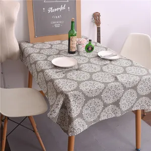 Détail de la nappe en lin gris avec motif mandala blanc sur une table à manger