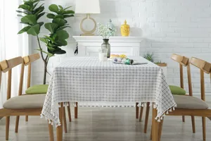 Detail of blue plaid tablecloth with decorative white fringe tassels on cotton linen fabric