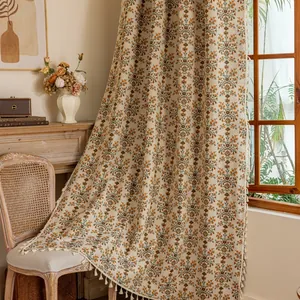 Detail van boho gordijn met kwastjes met dikke katoenen linnen textuur en retro bloemenprint