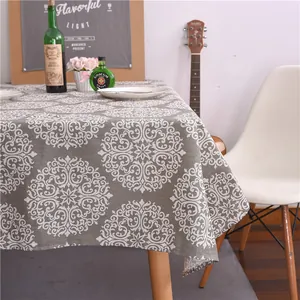 Gros plan d'une nappe en coton et lin gris avec motif mandala blanc dans un intérieur