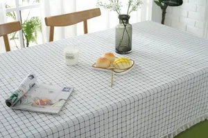 Detail of blue checkered cotton linen tablecloth with elegant white fringe tassels