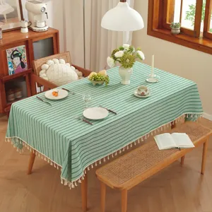 Detail van groen-wit gestreept tafelkleed met elegante witte franjes aan de randen