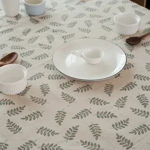 Vue détaillée d'une nappe en lin avec motif de feuilles vertes et mise en table élégante