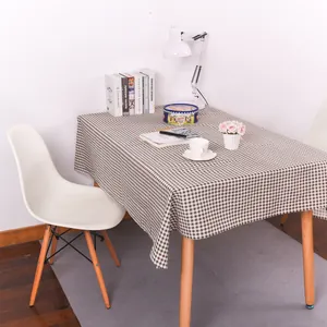 Detailweergave van het bruin-wit geruite katoenen linnen tafelkleed op houten tafel