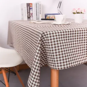 Detail van het bruin-wit geruite tafelkleed met natuurlijke drapering en weefstructuur