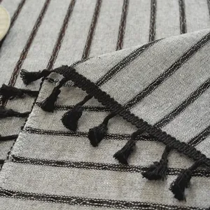 Close-up van Japans linnen tafelkleed met zwarte kwastjes en gestreepte textuur