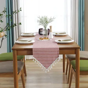Detail showing red and white striped cotton linen table runner with white tassels
