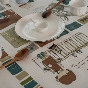 Détail de nappe en lin avec illustrations de jardin et motifs géométriques vintage