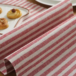 Detail of red and white striped cotton linen table runner with woven fabric texture