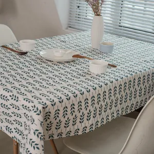 Détail de nappe en lin à motif feuilles bleu marine sur une table avec vaisselle