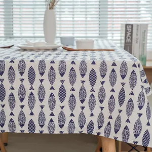 Gros plan d'une nappe en coton et lin avec des motifs de poissons bleus sur table en bois